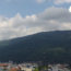 Picture of Quy Nhon, Vietnam with mountains and clouds in the background and city buildings in the foreground.