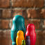 Picture of a series of Matryoshka dolls in front of a red brick wall