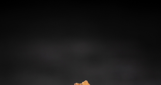 Image contains a black background with a small bit of light brown peaking up from the bottom.