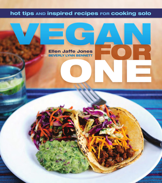 Image contains a photo of a single taco, guacamole, and a small salad on a plate. In the background, there is a glass of water with lime and a bowl of veggie ground beef. Text above the photo says "Hot tips and inspired recipes for cooking solo. Vegan For One. Ellen Jaffe Jones with Beverly Lynn Bennett."